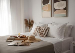 a bed with a tray of food and a hat on it at Blue Cyclades Villas in Kastraki