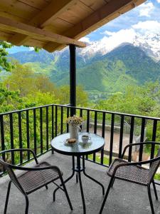 a table and two chairs on a balcony with mountains at Guesthouse in Lankhvri in Mestia