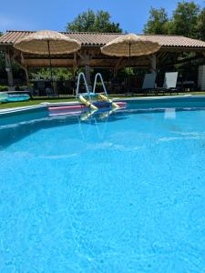 a swimming pool with two slides in the water at Gîtes climatisés classés 4 étoiles Au Petit Bonheur de Lorigné in Lorigné
