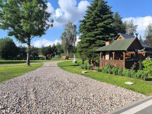 a gravel driveway with a gazebo in a park at Wśród Drzew - Tykocin in Tykocin