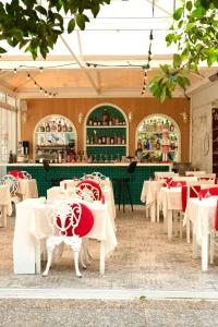a restaurant with white tables and chairs and a bar at Ada Palas Buyukada in Buyukada
