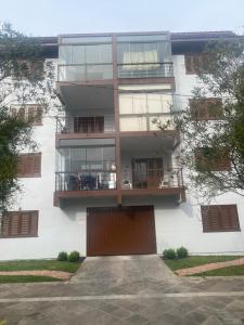 an apartment building with a door and a balcony at Hospede-se na Rua mais Charmosa e Visitada de Canela , aqui ninguém fica pra trás , traga seu Pet garagem fechada , faça tudo a pé , ideal para famílias e casais in Canela