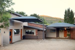 two large umbrellas sitting outside of a building at Mon Cheri Clarens in Clarens