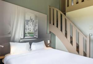a bedroom with a white bed and a staircase at B&B HOTEL Beauvais in Beauvais