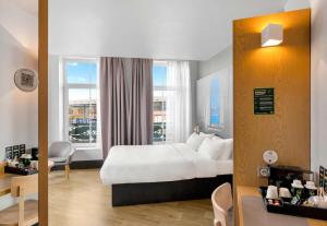 a hotel room with a white bed and a window at B&B HOTEL Dunkerque Centre Gare in Dunkerque