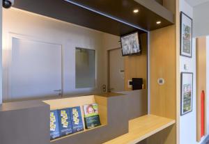 a waiting room with books on a shelf at B&B HOTEL Lieusaint Carré Sénart in Lieusaint +18 photos