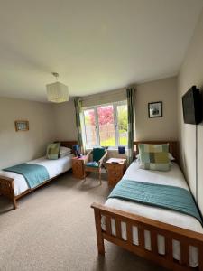 a bedroom with two beds and a window at The Rowans B&B in Connel +12 photos