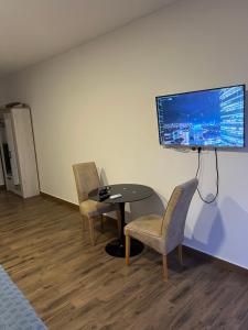 a room with a table and two chairs and a flat screen tv at Alex apartment Bar in Bar
