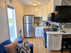 a kitchen with a stainless steel refrigerator and white cabinets at Steps to the Ocean! 219 in North Topsail Beach +20 photos