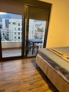 a bedroom with a bed and a balcony with a table at Alex apartment Bar in Bar +4 photos