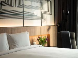 a bedroom with a bed and a vase of flowers at Pullman Lima Miraflores in Lima