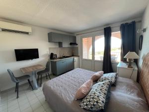 a bedroom with a bed and a kitchen with a desk at Résidence les pieds dans l'eau in Porto-Vecchio