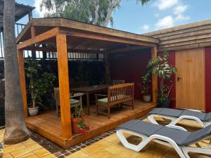 a wooden deck with a table and chairs at Villa Lajares Red House Fuerteventura in Lajares