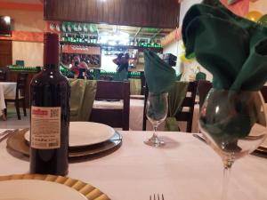 a bottle of wine sitting on a table with a wine glass at Complexe La Belle Rosie in Les Cayes