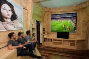 a group of people sitting in a room watching a soccer game at La Chimba Hostel in Santiago