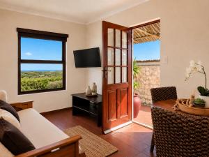 a living room with a couch and a table and a door at Baviana Beach Lodge - Jacobsbaai - Jacobs Bay in Jacobs Bay