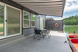a patio with a table and chairs on a house at Miss Madison - Pet Friendly Floating House in Russell Springs
