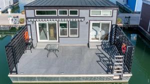 a tiny house on a dock next to the water at Miss Madison - Pet Friendly Floating House in Russell Springs