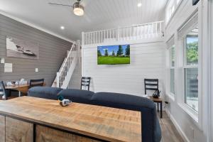 a living room with a couch and a tv on the wall at Miss Madison - Pet Friendly Floating House in Russell Springs