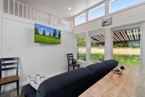 a living room with a couch and a tv on the wall at Miss Madison - Pet Friendly Floating House in Russell Springs +10 photos