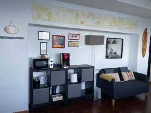 a living room with a couch and a microwave at Ibinaga Seaview - Auto checking property in Ibarrangelu
