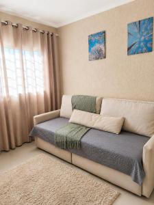 a couch in a room with a window at Ampla, com 5 vagas de carro e bem próxima das empresas da região in São José dos Pinhais
