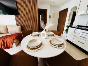 a living room with a white table with plates on it at CaboNegro Appart Resort, Piscine, Plage, Détente in Cabo Negro +16 photos