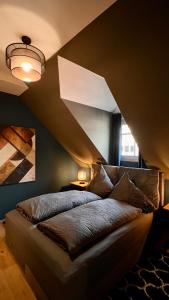 a bed in a room with a large angled ceiling at H-85 SUITES - BRIGHT Collection in Koblenz
