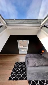 a attic room with a couch and a window at H-85 SUITES - BRIGHT Collection in Koblenz