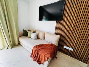 a couch with a blanket on it in a room at CaboNegro Appart Resort, Piscine, Plage, Détente in Cabo Negro