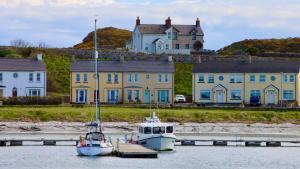 two boats docked in the water in front of houses at The Wheelhouse, Ballycastle in Ballycastle