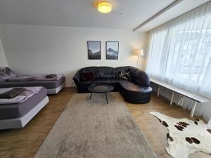 a living room with a leather couch and a table at Apartment Sunnmatt 752 by Interhome in Engelberg