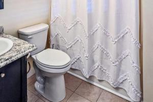 a bathroom with a toilet and a shower curtain at Champagne Supernova in Ludlow