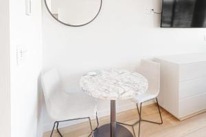 a round table with two white chairs and a mirror at Mellow on Meadow Mile 2B in Fraser