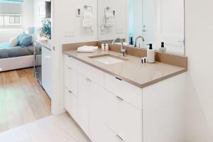 a white kitchen with a sink and a bed at Mellow on Meadow Mile 2B in Fraser +12 photos