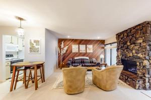 a living room with a stone fireplace and a table and chairs at Bliss at the Base in Ketchum