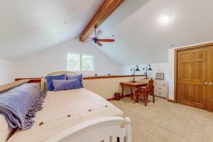 a bedroom with a bed with a ceiling fan and a desk at Blue River Grove in Silverthorne