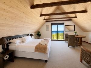 a bedroom with a large bed and a wooden ceiling at Baviana Beach Lodge - Jacobsbaai - Jacobs Bay in Jacobs Bay