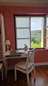 a desk with a chair in front of a window at La casina de Pili in Villaviciosa