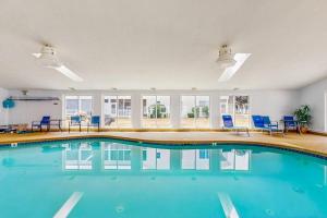 a swimming pool in a building with blue chairs at Wellington Manor 240 in Wells