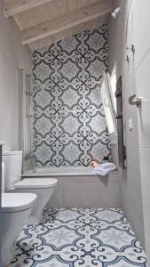 a bathroom with a white toilet and a tile wall at La casina de Pili in Villaviciosa +13 photos