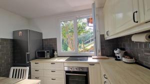 a kitchen with white cabinets and a window at La casina de Pili in Villaviciosa