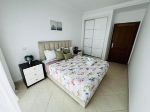a bedroom with a bed and a dresser and a door at CaboNegro Appart Resort, Piscine, Plage, Détente in Cabo Negro