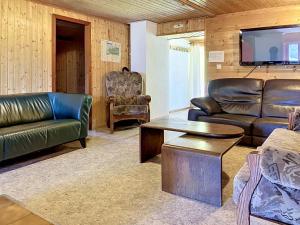 a living room with leather furniture and a flat screen tv at Apartment Chalet Anthamatten-2 by Interhome in Champéry