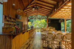 a bar in a restaurant with chairs and tables at Bungalows Beachfront Hotel in Punta Uva