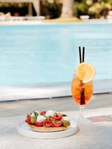 a plate with a sandwich and a drink on a table at Minerva Resort Hotel in Paestum