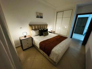 a bedroom with a large bed with two lamps on it at CaboNegro Appart Resort, Piscine, Plage, Détente in Cabo Negro