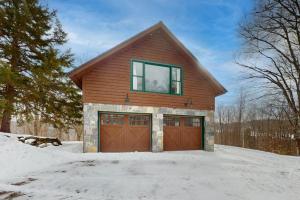 a house with two garage doors in the snow at The Loft at Fort Defiance in Barnard