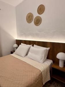 a bedroom with a bed with white sheets and pillows at Mosaic House in Sami