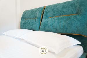 a surfboard on top of a bed with white pillows at The Core Lezhe in Lezhë